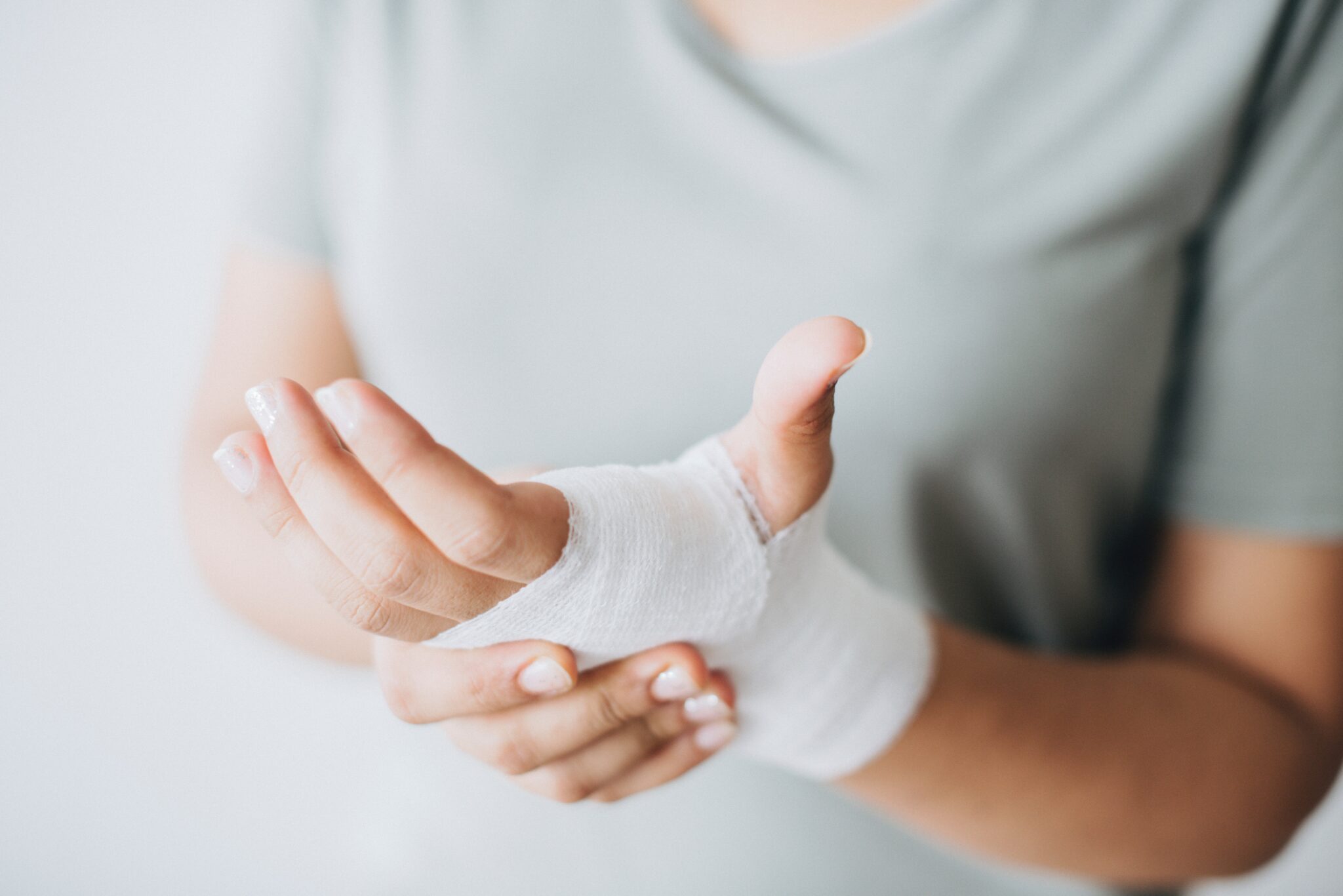 woman holding bandaged hands