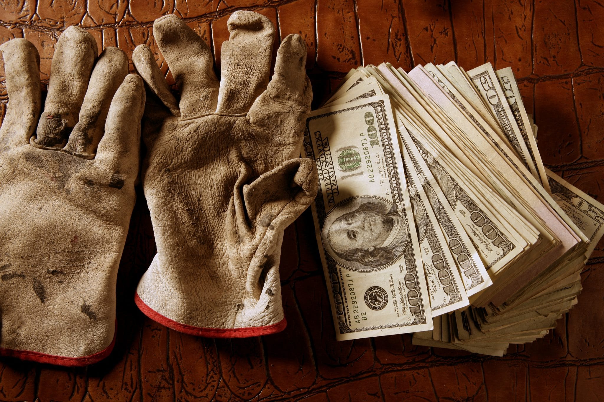 work gloves next to stack of money