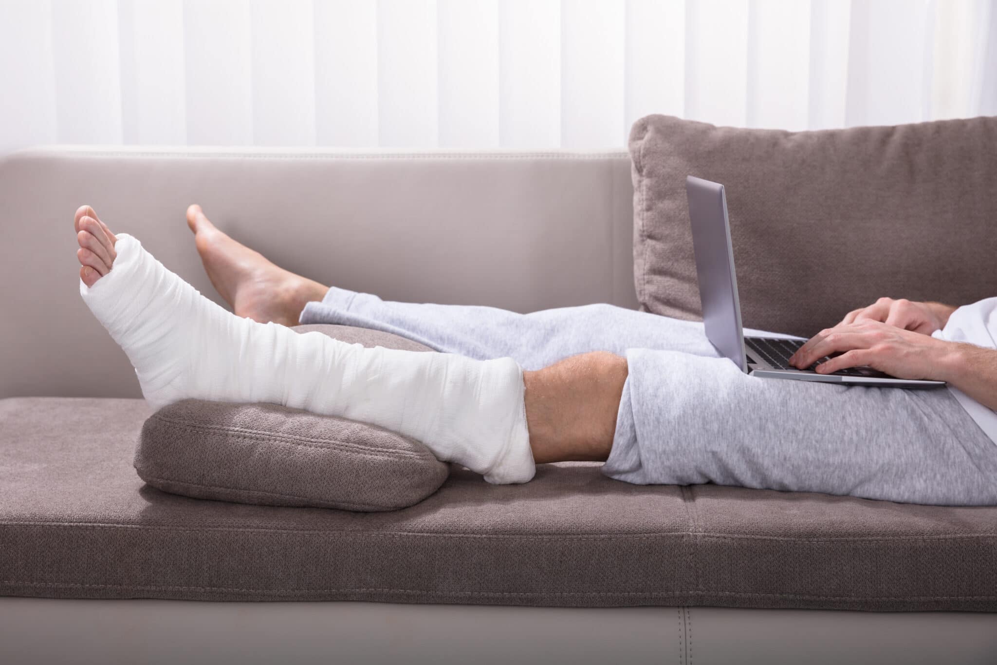 Man with broken leg sitting on couch
