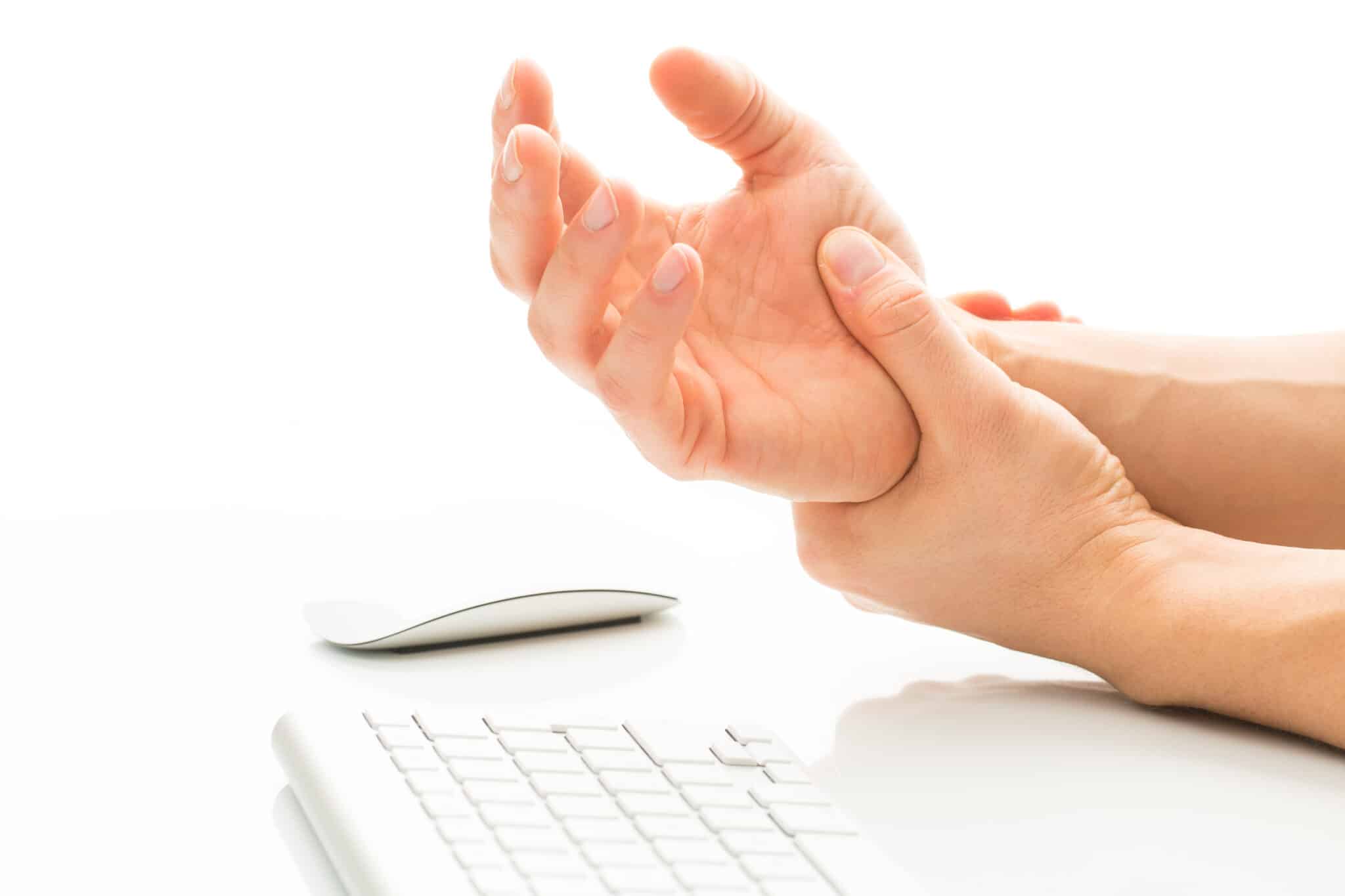 man holding wrist after typing