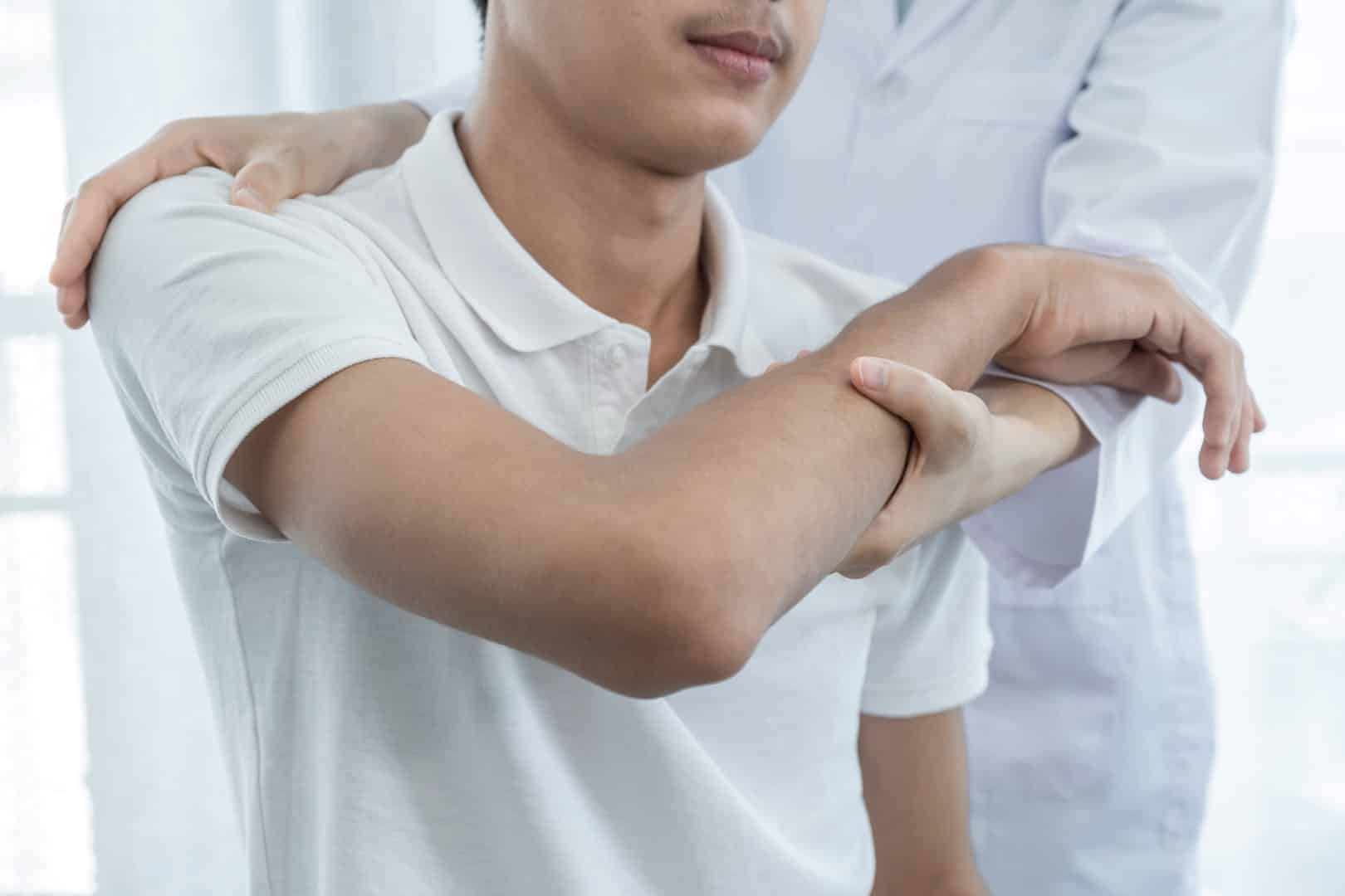 doctor examining patient's shoulder and arm